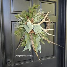 a wreath with antlers and pine cones on the front door is decorated with greenery