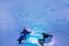 a woman sitting on a bench in the middle of an ice cave filled with snow