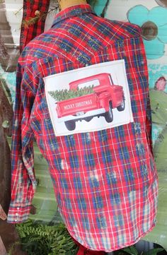 a red truck with a christmas tree on it's back is sitting in front of a window