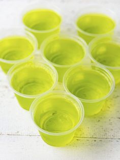 green cups filled with liquid sitting on top of a white table