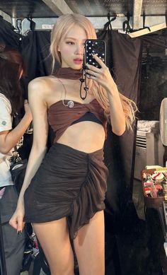 a woman taking a selfie in front of a mirror wearing a skirt and top