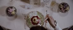 a person is sitting at a table with plates and silverware on top of it