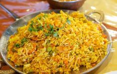 a plate full of rice and vegetables on a table