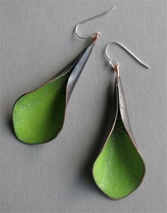 two pairs of green tear shaped earrings on a gray surface with silver earwires