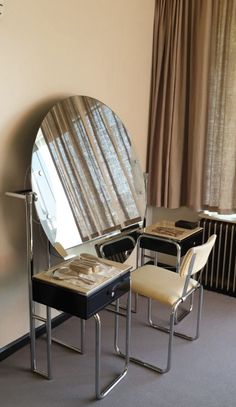 a mirror sitting on top of a table next to two chairs