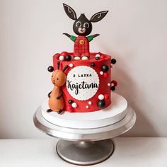 a red and white cake with an animal on top