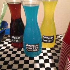 three different colored vases sitting on a checkered table