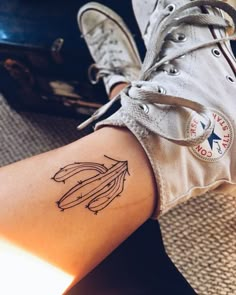 a woman's foot with a tattoo on her left leg and an arrow in the middle