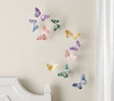 a white bed sitting next to a wall with butterflies on it