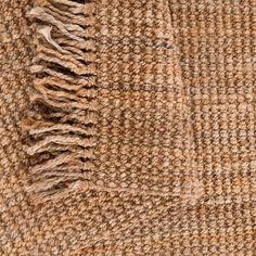 a brown and tan checkered fabric with fringes on the end, close up