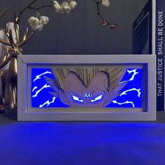 a blue light up shadow box with the image of gohan on it and some white flowers