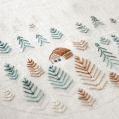 an embroidered piece with leaves on it is shown in the shape of a hedgehog