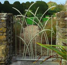 an iron gate in the middle of a garden