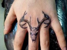 a hand with a deer head tattoo on it