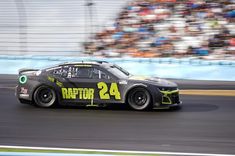 a car driving down a race track in front of a crowd