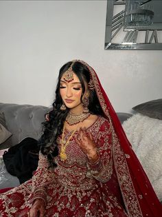 a woman sitting on top of a couch in a red dress