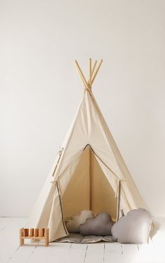 a teepee tent with pillows and candles on the floor