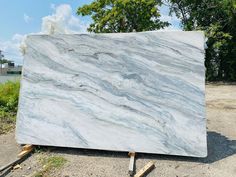 a large white marble slab sitting on top of a pile of wood