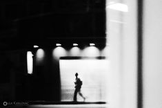 black and white photograph of a person walking in the dark