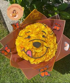 there is a cake made to look like a face on top of some orange flowers