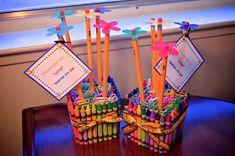 two baskets filled with crayons sitting on top of a wooden table