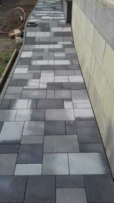 the sidewalk is lined with black and white bricks, which are laid diagonally on each side