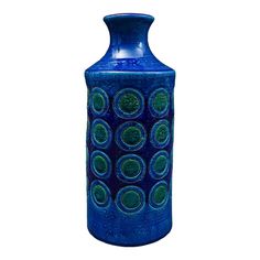 a blue vase with circles painted on the outside and inside, sitting in front of a white background