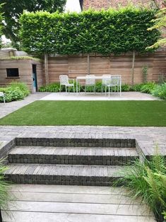 an outdoor patio with grass and lawn furniture