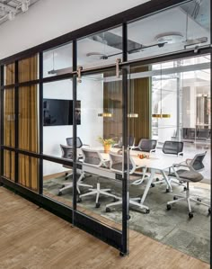 an office meeting room with glass walls and sliding doors that open up to the outside