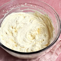 a glass bowl filled with batter on top of a pink cloth