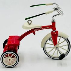 a red and white toy tricycle on a white background with the words mini - cruiser written below it