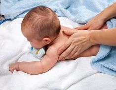 a woman holding a baby on top of a blanket