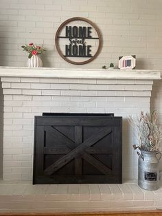 a fireplace with a sign above it that says home is where the heart is on top