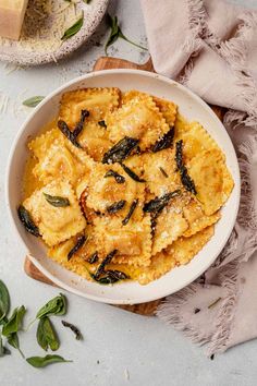 a white bowl filled with pasta and spinach