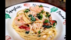 a white plate topped with pasta and shrimp