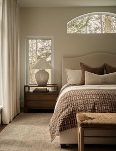 a bedroom with a bed, nightstand and window in it's centerpieces