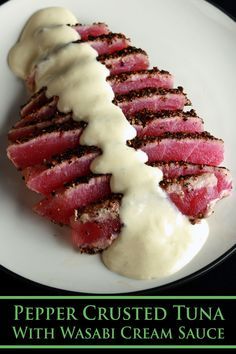 a white plate topped with meat covered in sauce