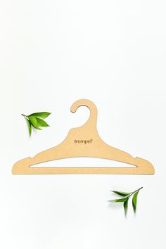 a wooden hanger with the word'tremport'on it and two green leaves