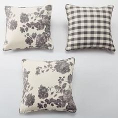 four black and white pillows with flowers on them, one in the middle has a gingham checkerboard pattern