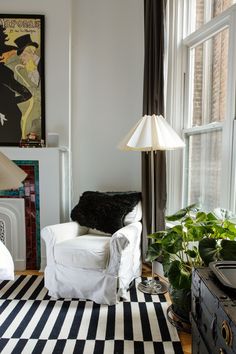 a living room with a black and white checkered rug on the floor next to a chair