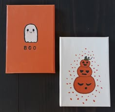 two canvases with pumpkins and ghost faces on them, one is orange and the other is white