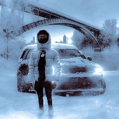 a man standing in the snow next to a car