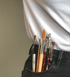 there are many pens and pencils in the pocket of a person's jeans