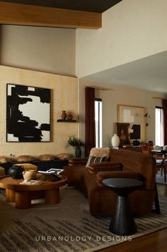 a living room filled with furniture and a painting hanging on the wall above it's fireplace