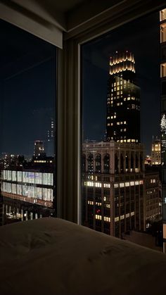 a view of the city at night from a hotel room in new york, ny