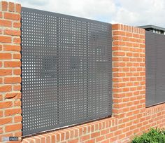 a brick wall with a metal screen on it