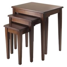 three wooden nesting tables with one sitting on the floor and another standing up against it