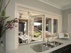 a kitchen sink sitting under a window next to a counter top