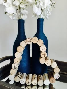 two blue vases filled with white flowers and wine corks