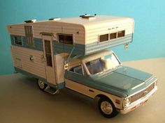 a toy truck with a trailer attached to it's bed and an rv on the back